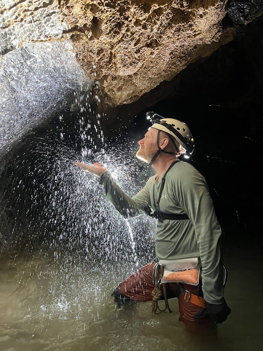 Caving in Vietnam — cupping water from a cave waterfall